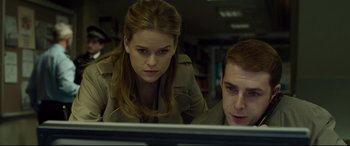 Movie still from “Criminal” (2016), directed by Ariel Vromen – A woman and a man looking at a computer screen; Medium shot, Low angle