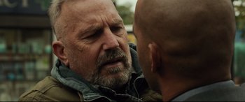 Movie still from “Criminal” (2016), directed by Ariel Vromen – A man is talking to another man outside; Close Up shot, Over the shoulder angle