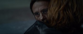 Movie still from “Criminal” (2016), directed by Ariel Vromen – A person wearing glasses and a leather jacket; Close Up shot, Over the shoulder angle
