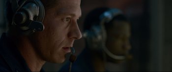 Movie still from “Criminal” (2016), directed by Ariel Vromen – A person wearing a headset; Close Up shot, Low angle