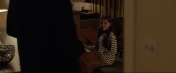 Movie still from “Criminal” (2016), directed by Ariel Vromen – A young girl sitting at a piano playing the piano; Medium shot, Over the shoulder angle