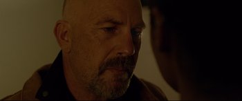 Movie still from “Criminal” (2016), directed by Ariel Vromen – A person with a beard; Close Up shot, Over the shoulder angle