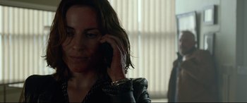 Movie still from “Criminal” (2016), directed by Ariel Vromen – A person talking on a cell phone; Close Up shot, Over the shoulder angle