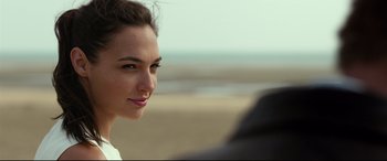 Movie still from “Criminal” (2016), directed by Ariel Vromen – A person sitting on a beach; Close Up shot, Over the shoulder angle