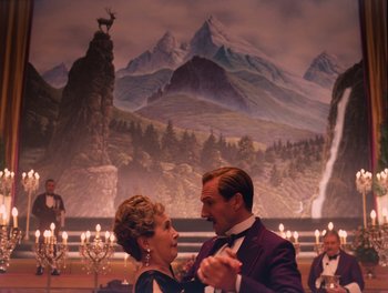 Movie still from “The Grand Budapest Hotel” (2014), directed by Wes Anderson – A man and a woman dancing in front of a painting; Medium shot, Low angle