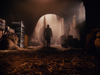 Movie still from “The Grand Budapest Hotel” (2014), directed by Wes Anderson – A man walking through a tunnel in the dark; Wide shot, Low angle