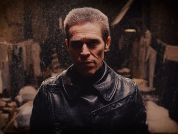 Movie still from “The Grand Budapest Hotel” (2014), directed by Wes Anderson – A man wearing a leather jacket standing in front of statues; Close Up shot, Low angle