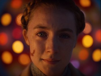 Movie still from “The Grand Budapest Hotel” (2014), directed by Wes Anderson – A young woman with a braid is looking at the camera; Close Up shot, Over the shoulder angle