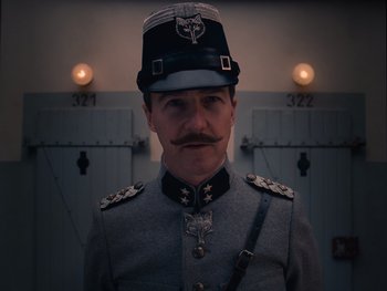 Movie still from “The Grand Budapest Hotel” (2014), directed by Wes Anderson – A man in a military uniform with a mustache; Close Up shot, Low angle