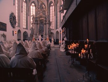 Movie still from “The Grand Budapest Hotel” (2014), directed by Wes Anderson – A group of people sitting in front of a stage; Extreme Wide shot, High angle