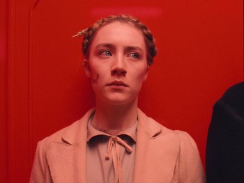 Movie still from “The Grand Budapest Hotel” (2014), directed by Wes Anderson – A woman in a pink coat with a bow in her hair; Close Up shot, Overhead angle
