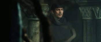 Movie still from “Crimson Rivers 2: Angels of the Apocalypse” (2004), directed by Olivier Dahan – A man wearing a black robe and a black hat; Close Up shot, Over the shoulder angle