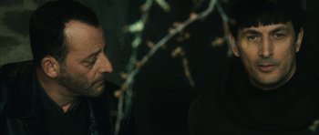 Movie still from “Crimson Rivers 2: Angels of the Apocalypse” (2004), directed by Olivier Dahan – A person looking down at a tree branch; Close Up shot, Over the shoulder angle