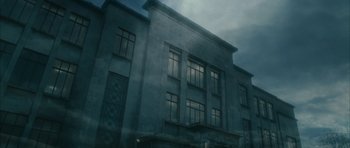 Movie still from “Crimson Rivers 2: Angels of the Apocalypse” (2004), directed by Olivier Dahan – A large building with many windows on a cloudy day; Extreme Wide shot, Low angle