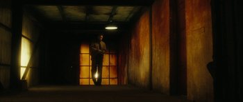 Movie still from “Crimson Rivers 2: Angels of the Apocalypse” (2004), directed by Olivier Dahan – A man is standing in a dark hallway; Wide shot, Low angle