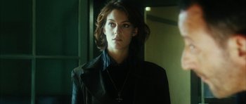 Movie still from “Crimson Rivers 2: Angels of the Apocalypse” (2004), directed by Olivier Dahan – A woman in a leather jacket with a cross on her neck; Close Up shot, Low angle