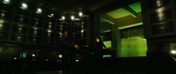 Movie still from “Crimson Rivers 2: Angels of the Apocalypse” (2004), directed by Olivier Dahan – Two people sitting in a dark room at night; Wide shot, Low angle
