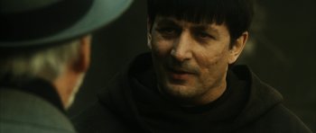 Movie still from “Crimson Rivers 2: Angels of the Apocalypse” (2004), directed by Olivier Dahan – A person wearing a monk's outfit; Close Up shot, Over the shoulder angle