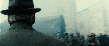 Movie still from “Crimson Rivers 2: Angels of the Apocalypse” (2004), directed by Olivier Dahan – A man wearing a hat looking out a window; Close Up shot, Over the shoulder angle