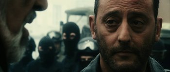 Movie still from “Crimson Rivers 2: Angels of the Apocalypse” (2004), directed by Olivier Dahan – A group of people in black masks and a man in a black shirt; Close Up shot, Over the shoulder angle