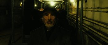 Movie still from “Crimson Rivers 2: Angels of the Apocalypse” (2004), directed by Olivier Dahan – An old man with a beard wearing a suit and a hat; Close Up shot, Low angle