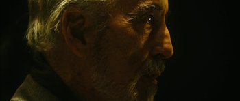 Movie still from “Crimson Rivers 2: Angels of the Apocalypse” (2004), directed by Olivier Dahan – An older man with a beard and a mustache; Extreme Close Up shot, Over the shoulder angle