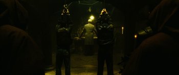Movie still from “Crimson Rivers 2: Angels of the Apocalypse” (2004), directed by Olivier Dahan – Two men standing next to each other in a dark room; Wide shot, Low angle