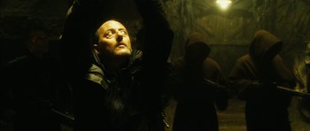 Movie still from “Crimson Rivers 2: Angels of the Apocalypse” (2004), directed by Olivier Dahan – A man with a beard and a mustache is looking up; Close Up shot, Low angle
