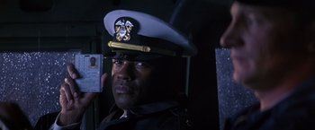 Movie still from “Crimson Tide” (1995), directed by Tony Scott – A man in a military uniform is holding his id card; Close Up shot, High angle