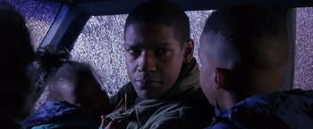 Movie still from “Crimson Tide” (1995), directed by Tony Scott – A man with a beard and a jacket is looking at the camera; Close Up shot, Over the shoulder angle