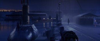 Movie still from “Crimson Tide” (1995), directed by Tony Scott – A person walking on a dock at night; Extreme Wide shot, High angle