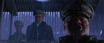 Movie still from “Crimson Tide” (1995), directed by Tony Scott – A man in a military uniform is looking at another man in a uniform; Close Up shot, Low angle