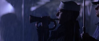 Movie still from “Crimson Tide” (1995), directed by Tony Scott – A man in a sailor's uniform blowing into a horn; Close Up shot, Low angle