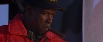 Movie still from “Crimson Tide” (1995), directed by Tony Scott – A person holding a cigar; Close Up shot, Low angle