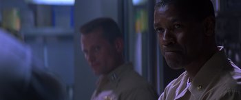 Movie still from “Crimson Tide” (1995), directed by Tony Scott – Two men are standing side by side in the dark; Close Up shot, Low angle