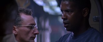 Movie still from “Crimson Tide” (1995), directed by Tony Scott – Two men talking to each other in a dark room; Close Up shot, Low angle