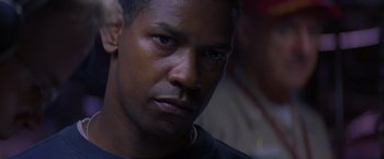 Movie still from “Crimson Tide” (1995), directed by Tony Scott – A man's face in a dark room; Close Up shot, Over the shoulder angle