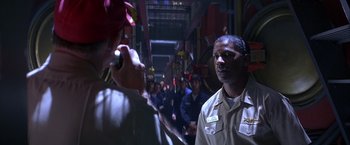 Movie still from “Crimson Tide” (1995), directed by Tony Scott – A group of people standing in a room; Close Up shot, Over the shoulder angle