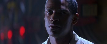 Movie still from “Crimson Tide” (1995), directed by Tony Scott – A man's face in a dimly - lit room; Close Up shot, Low angle