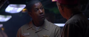 Movie still from “Crimson Tide” (1995), directed by Tony Scott – A man in a uniform talking to another man; Close Up shot, Over the shoulder angle
