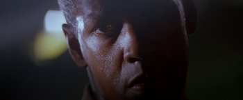 Movie still from “Crimson Tide” (1995), directed by Tony Scott – A man's face with a dark background; Extreme Close Up shot, Low angle