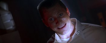 Movie still from “Crimson Tide” (1995), directed by Tony Scott – A person with a smile on their face; Close Up shot, Low angle