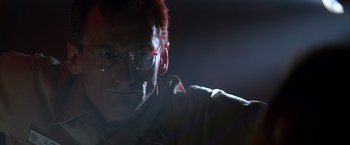 Movie still from “Crimson Tide” (1995), directed by Tony Scott – A person wearing glasses and a jacket; Close Up shot, Low angle