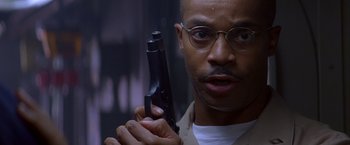 Movie still from “Crimson Tide” (1995), directed by Tony Scott – A man holding a gun up to his face; Close Up shot, Low angle