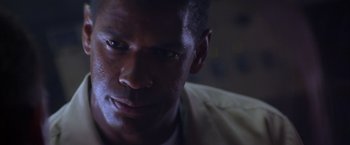 Movie still from “Crimson Tide” (1995), directed by Tony Scott – A man's face in the dark; Close Up shot, Low angle