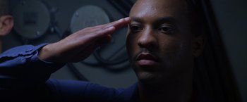 Movie still from “Crimson Tide” (1995), directed by Tony Scott – A man saluting with a hand touching his forehead; Close Up shot, Low angle
