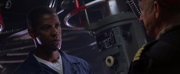 Movie still from “Crimson Tide” (1995), directed by Tony Scott – A man standing in front of an industrial machine; Close Up shot, Low angle