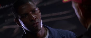 Movie still from “Crimson Tide” (1995), directed by Tony Scott – A man's face in a darkened room; Close Up shot, Low angle