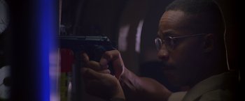 Movie still from “Crimson Tide” (1995), directed by Tony Scott – A man holding a gun in his hands; Close Up shot, Low angle