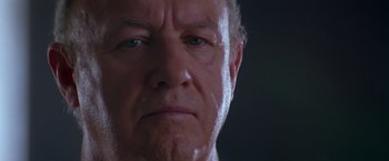 Movie still from “Crimson Tide” (1995), directed by Tony Scott – An older man with blue eyes stares into the camera; Close Up shot, Low angle